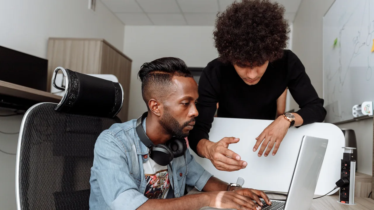 Two people working together at a laptop