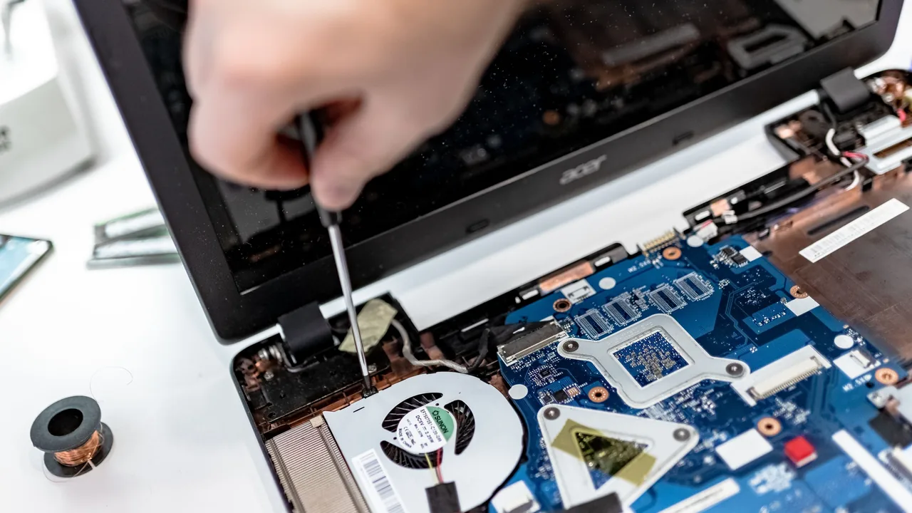 Technician repairing an open laptop