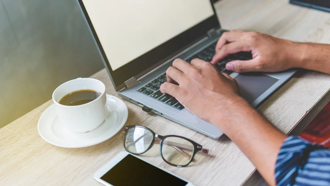 Person using a laptop and phone
